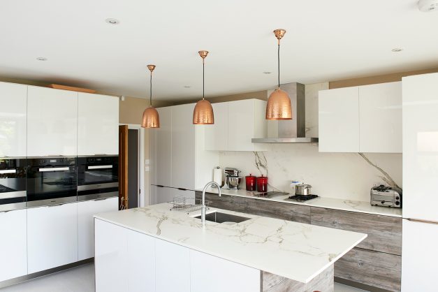 Refurbished kitchen with cooper pendants and marble worktop and splash back